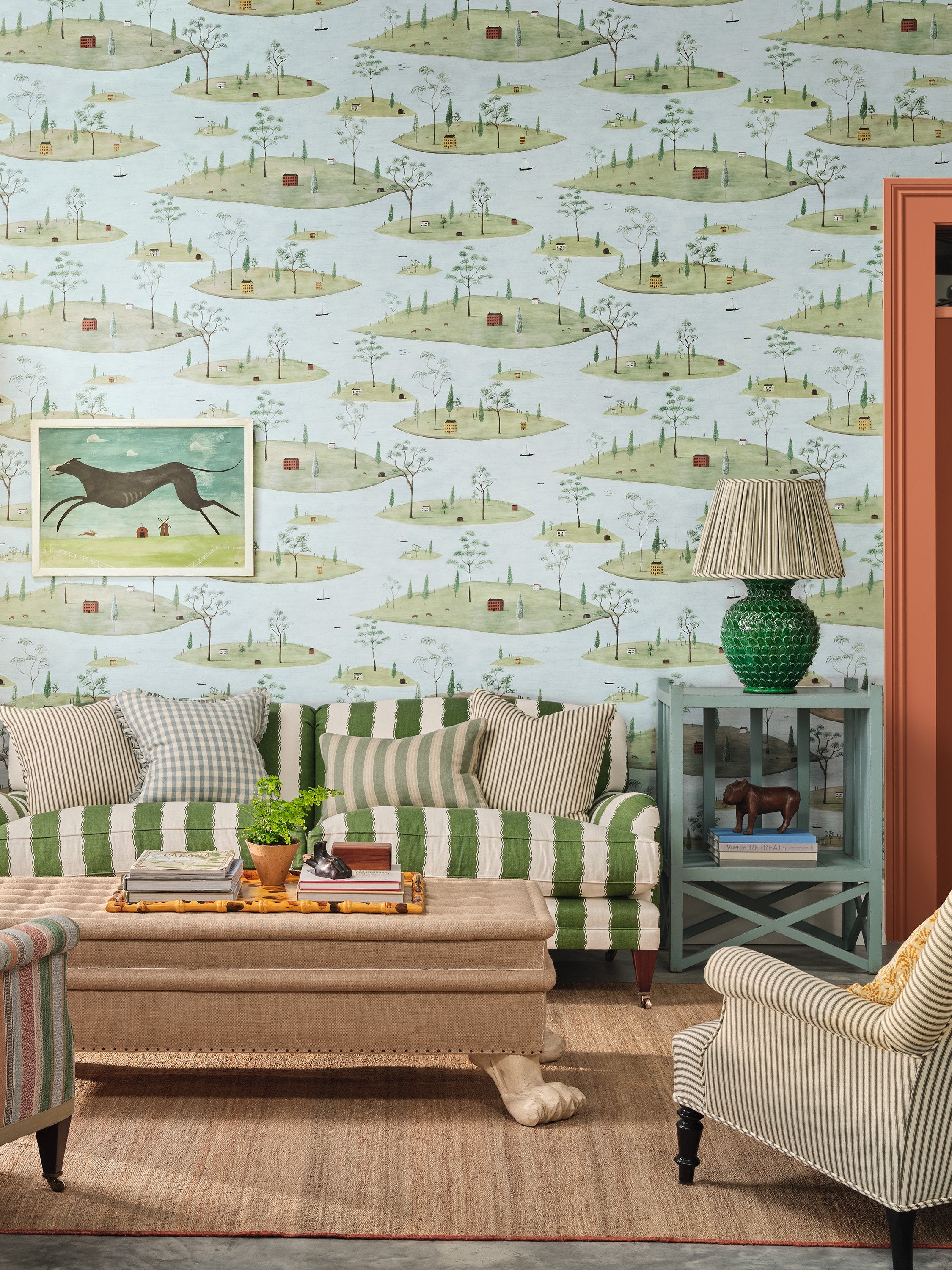 Harbour wallpaper with stripy sofa, side table, lamp and woven rug