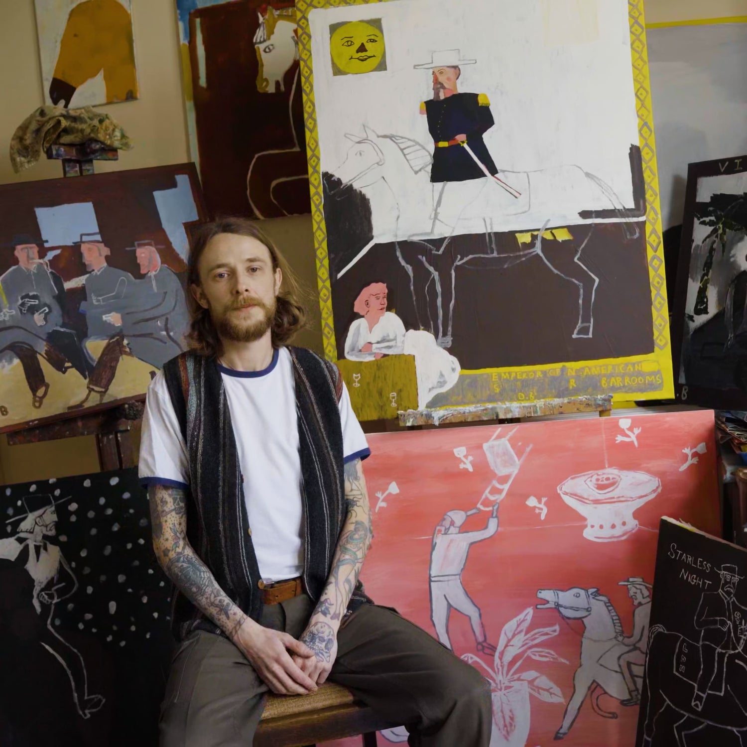 Photo of Dan Bloodworth in his studio surrounded by artwork